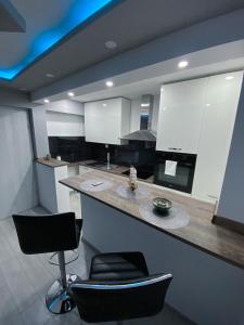 a kitchen with a counter with two chairs and a bar at Apartment Carpe Diem in Koper