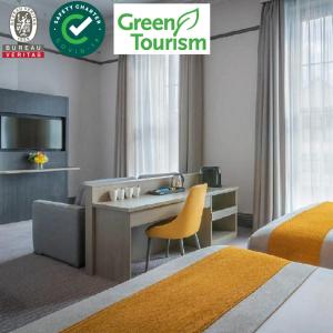 a hotel room with a bed, chair and a television at Maldron Hotel Parnell Square in Dublin