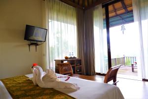 1 dormitorio con decoración de cisne en una cama en Swar Bali Lodge en Munduk