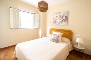 1 dormitorio con cama blanca y ventana en Mirador de la Ermita en Montejaque