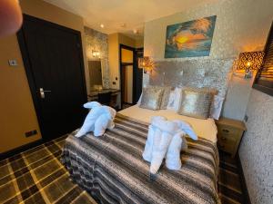 Dos toallas en una cama en una habitación de hotel en The Albert Inn, en Nairn