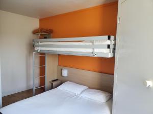 a bedroom with a bed and two bunk beds at PREMIERE CLASSE ANGERS SUD Louvre Hotels group in Les Ponts-de-Cé