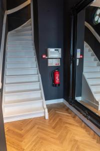 een trappenhuis met een spiegel en een brandblusser bij Stadslogement Hoogend in Sneek