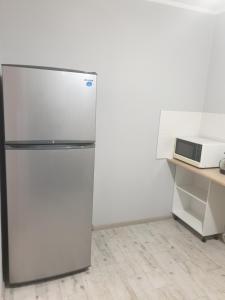 un réfrigérateur dans une cuisine à côté d'un four micro-ondes dans l'établissement Квартира на бульваре Вечернем, à Kryvy Rih