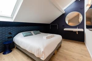 a bedroom with a large bed and a mirror at Le Chat Qui Dort - Vieux Lille III in Lille
