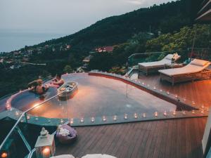 un balcón con una piscina con luces encendidas en Lissiya Hotel, en Faralya