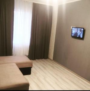 a room with two beds and a tv on the wall at Квартира на бульваре Вечернем in Kryvyi Rih