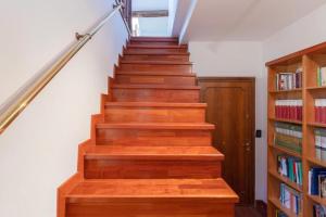 un escalier avec des marches en bois et une étagère à livres dans l'établissement Cozy Attico dei Furlani up 4 persons, WIFI and A/C, à Venise