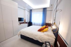 una camera da letto con un letto con cuscini gialli e una TV di Napoli City Center - Appartamenti e Camere a Napoli