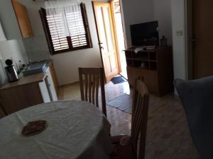 a kitchen with a table and a kitchen with a television at Jagoda Apartments in Zaostrog