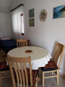 a dining room with a table and two chairs at Jagoda Apartments in Zaostrog