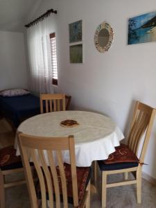 una sala da pranzo con un tavolo e due sedie di Jagoda Apartments a Zaostrog