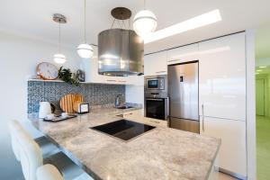 een keuken met een groot marmeren aanrecht en apparatuur bij Beach Front Apartment-1st Line in Marbella