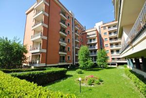 an apartment complex with a lawn in front of a building at Modern apartment in Vercelli - 50 m² with balcony in Vercelli