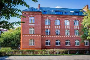 a large red brick building with white windows at Dom & House - Apartments Waterlane Vintage in Gdańsk