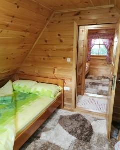 a bedroom in a log cabin with a bed at Brvnara Tara in Bajina Bašta