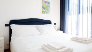 un letto bianco con due asciugamani sopra di Italianway - Sertorelli 2 a Bormio
