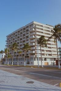 a large building with palm trees in front of it at Hotel Royalty in Veracruz