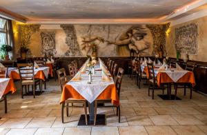 a dining room with tables and chairs and a mural at Hotel-Restaurant Zum Bäumle in Süßen
