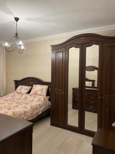 1 dormitorio con 1 cama y vestidor con espejo en Уютная квартира со всеми удобствами, en Ereván