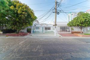 an empty street in front of a white fence at Hotel Ayenda Casa Paraiso 1327 in Barranquilla