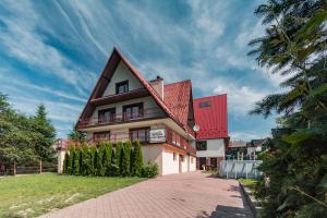 una casa con techo rojo y entrada de ladrillo en Willa Wiesia Rabka Zdrój, en Rabka