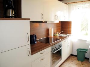 a kitchen with white cabinets and a sink at Holiday Home Boche by Interhome in Goos