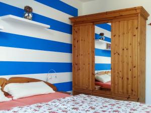 ブレーゲにあるApartment Kapitänskajüte by Interhomeの青と白のストライプの壁のベッドルーム(ベッド1台付)