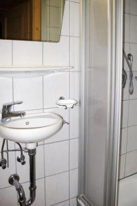 a white bathroom with a sink and a mirror at Apartment Bauernhaus Schusterhäusl by Interhome in Schwendau +34 photos