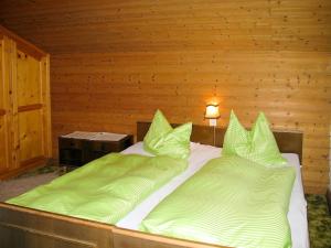 a bedroom with two beds with green pillows at Apartment Bauernhaus Schusterhäusl by Interhome in Schwendau