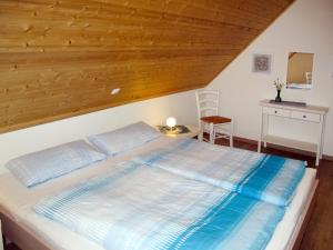 a large bed in a room with a wooden ceiling at Holiday Home Sanddorn by Interhome in Altefähr