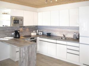 a kitchen with white cabinets and a counter top at Holiday Home Sanddorn by Interhome in Altefähr
