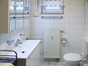 La salle de bains blanche est pourvue de toilettes et d'un lavabo. dans l'établissement Apartment Glowe - GLW654 by Interhome, à Klein Gelm