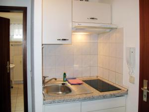 Apartment Glowe - GLW654 by Interhome في Klein Gelm: طاولة مطبخ مع حوض وهاتف