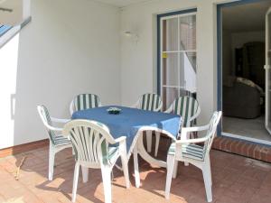 a blue table and chairs on a patio at Apartment Gartenstraße-1 by Interhome in Ostseebad Karlshagen