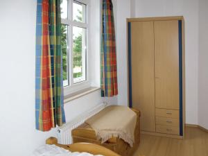 ein Schlafzimmer mit einem Fenster und einem Stuhl neben einem Schrank in der Unterkunft Apartment Stubbenkammer by Interhome in Breege + 6 Fotos