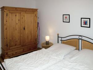 ein Schlafzimmer mit einem Bett und einem Holzschrank in der Unterkunft Apartment Stubbenkammer by Interhome in Breege