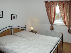 Schlafzimmer mit einem weißen Bett und einem Fenster in der Unterkunft Apartment Stubbenkammer by Interhome in Breege