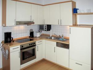 eine Küche mit weißen Schränken und einer Spüle in der Unterkunft Apartment Stubbenkammer by Interhome in Breege