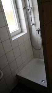 a bathroom with a shower with a tub and a window at Albergo Restaurante Da Franco in Büchenbeuren