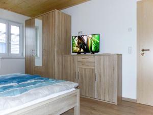 a bedroom with a bed and a tv on a wall at Holiday Home Rügenperle by Interhome in Altefähr +17 photos