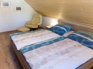a bedroom with two beds and a chair at Holiday Home Rügenperle by Interhome in Altefähr