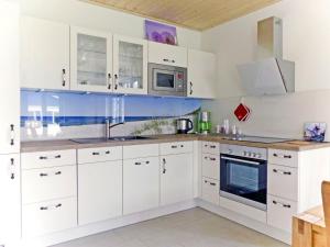 a white kitchen with white cabinets and appliances at Holiday Home Rügenperle by Interhome in Altefähr