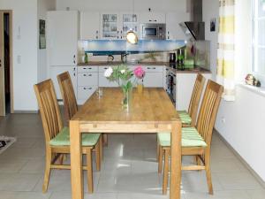 a dining room table with chairs and a vase of flowers at Holiday Home Rügenperle by Interhome in Altefähr