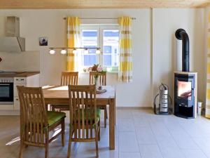 a kitchen and dining room with a table and a fireplace at Holiday Home Rügenperle by Interhome in Altefähr