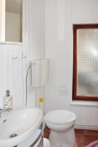 a white bathroom with a toilet and a sink at Holiday Home Jana by Interhome in Buchholz