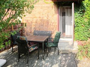 a wooden table and chairs in front of a brick building at Holiday Home Jana by Interhome in Buchholz