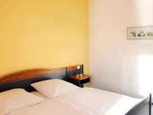 a bedroom with two white beds and a yellow wall at Apartment Lagunenstadt Ueckermünde-3 by Interhome in Ueckermünde