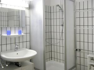a white bathroom with a sink and a shower at Apartment Lagunenstadt Ueckermünde-3 by Interhome in Ueckermünde