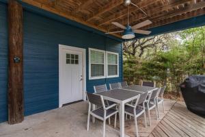 een blauw huis met een tafel en stoelen op een terras bij The Nest on Lake Travis in Buffalo Gap